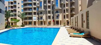 a swimming pool in front of a large apartment building at Charming 1-Bed Chalet in Hurghada in Hurghada