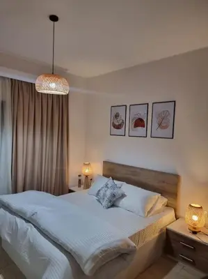 a bedroom with a large bed and a chandelier at Tolles Modernes Studio in Aldau in Hurghada