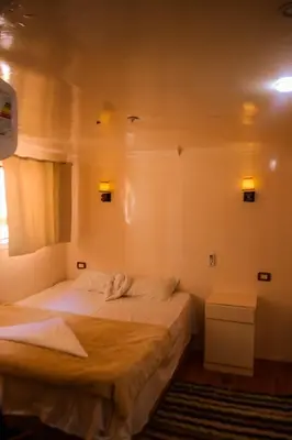 a bedroom with two beds in a room at Floating Hotel- Happy Nile Boat in Luxor