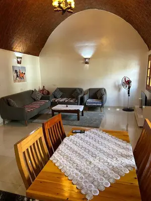 a living room with a table covered in white lace at The House Of Love in Luxor