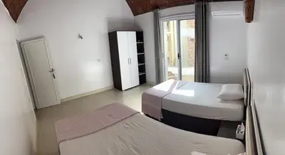 a small room with two beds and a window at The House Of Love in Luxor