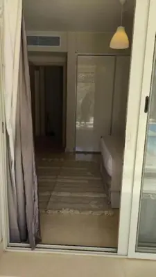 a door to a room with a couch and a window at Mangroovy Magic PoolView 1BR in Beachfront Complex M3 3A 13 in Hurghada