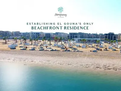 a beach with a bunch of beach chairs and buildings at Mangroovy Magic PoolView 1BR in Beachfront Complex M3 3A 13 in Hurghada