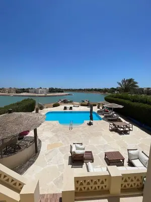 a patio with a swimming pool and chairs and a swimming pool at Spacious Villa with private pool-Gouna in Hurghada