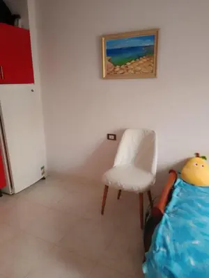 a room with a chair and a painting on the wall at Tiba View flat near pool in Hurghada