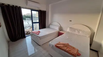 a small room with two beds and a window at NOBATiA Guest House 2 in Aswan