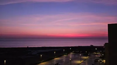 a sunset over the ocean with a street with lights at El Gouna Mangroovy Residence Sea View - kitesurfing in Hurghada