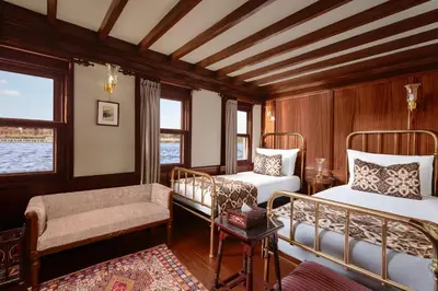 a bedroom with two beds and a chair and a couch at Farouz El Nil I Nile Cruise - Every Monday from Luxor for 07 & 05 Nights in Ţawd