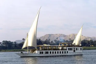 a white boat with two sails in the water at JAZ Farouz El Nil III Nile Cruise - Every Saturday from Luxor for 07 & 05 Nights in Luxor