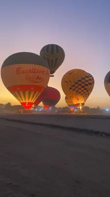 a group of hot air balloons on a field at Tibs mountain view in Al Aqālitah