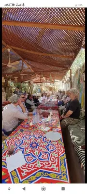 a group of people sitting at a long table at Tibs mountain view in Al Aqālitah