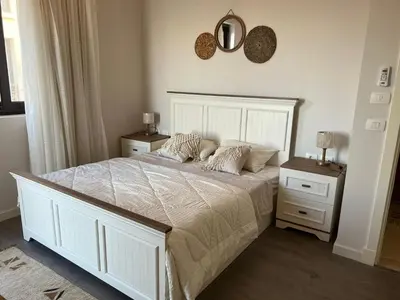a bedroom with a large white bed with two night stands at Luxury 4 bedroom villa - Cyan ElGouna in Hurghada