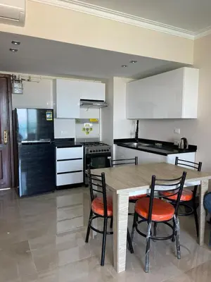 a kitchen with a wooden table and chairs in a room at شقه بغرفه نوم في الغردقه in Hurghada