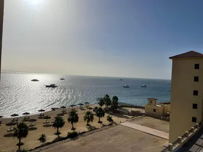 a beach with palm trees and boats in the water at شقه بغرفه نوم في الغردقه in Hurghada