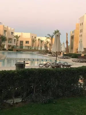 a pool at a resort with umbrellas and chairs at Mangroovy M7-4A-03 in Hurghada