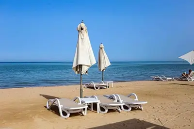 a group of lounge chairs and an umbrella on a beach at Mangroovy M7-4A-03 in Hurghada
