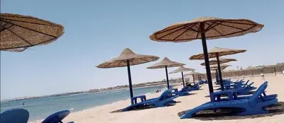 a group of chairs and umbrellas on a beach at Chalet front the beach in Hurghada