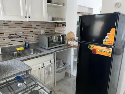 a kitchen with a black refrigerator and a microwave at Casa Della Laguna in Gouna in Hurghada