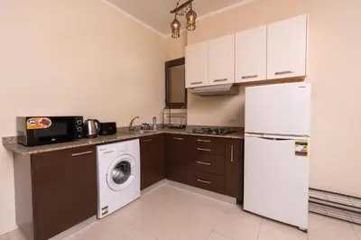 a kitchen with a washer and a white refrigerator at 2bedrooms apartment 53 in Hurghada