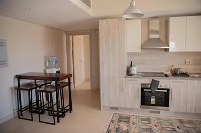 a kitchen with a counter and a table and a stove at Modern apartment with large pool & beach access in Hurghada