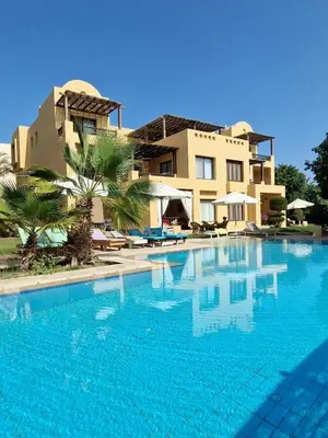 a large swimming pool in front of a building at Nubian Style Apartment, South Marina, El Gouna in Hurghada