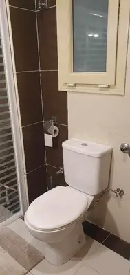 a bathroom with a white toilet and a window at Hurghada Cosy Apart in Hurghada