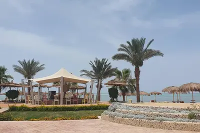 a resort with chairs and umbrellas on the beach at Hurghada Cosy Apart in Hurghada