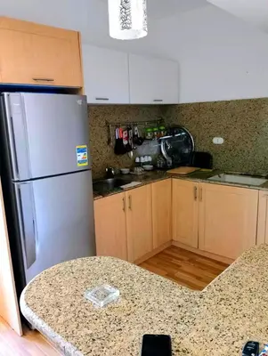 a kitchen with a stainless steel refrigerator and a table at Шале Stella di mare Makadi Хургада in Hurghada