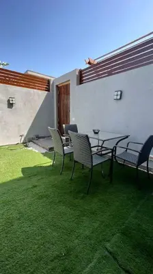 a patio with a table and chairs on the grass at 1BR villa - private heated pool in Bali ElGouna in Hurghada