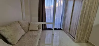 a living room with a couch in front of a window at Ubytovani v novém resortu Aqua Tropical poblíž El Gouny in Hurghada