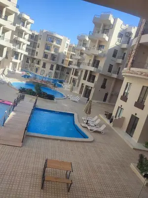 a swimming pool in front of a large apartment building at Ubytovani v novém resortu Aqua Tropical poblíž El Gouny in Hurghada