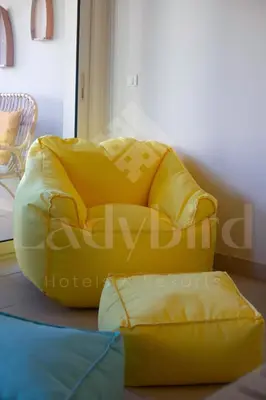 a yellow couch sitting in a room with a chair at Ladybird - Veranda Beach House in Hurghada