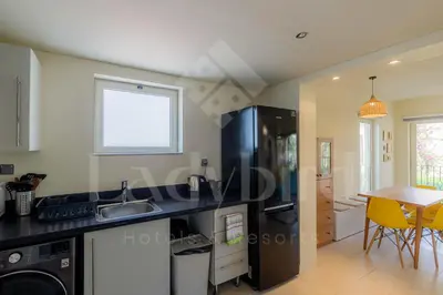 a kitchen with a sink and a table with yellow chairs at Ladybird - Veranda Beach House in Hurghada