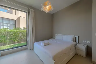 a bedroom with a bed and a large window at Elegant 4BR in Tawila, Gouna. Private Pool, Lagoon in Hurghada