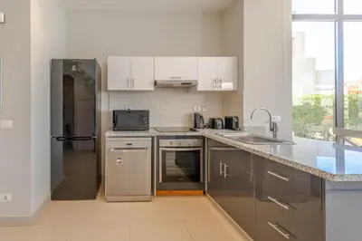 a kitchen with stainless steel appliances and gray cabinets at Elegant 4BR in Tawila, Gouna. Private Pool, Lagoon in Hurghada