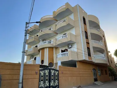 a building with balconies on the side of it at El Hady Apartments with Swimming Pool in Luxor