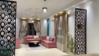 a living room with two pink couches and a mirror at El Hady Apartments with Swimming Pool in Luxor