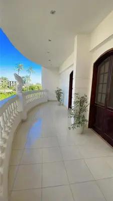 a balcony of a building with a door and plants at El Hady Apartments with Swimming Pool in Luxor