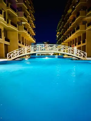 a bridge over a swimming pool in front of a building at Luna Blu Sea View in Hurghada