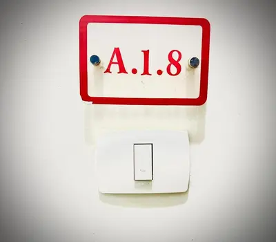 a red and white alarm clock next to a switch at Luna Blu Sea View in Hurghada