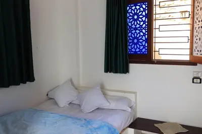 a bedroom with a bed with pillows and a window at Magic Place Luxor in Luxor
