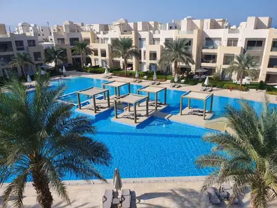 an overhead view of a pool with palm trees and buildings at Mangroovy 2BR with roof in Hurghada