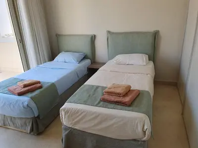 two beds in a room with towels on them at Mangroovy 2BR with roof in Hurghada