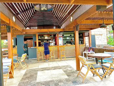 a person standing in front of a restaurant with tables and chairs at Top floor premier view chalet in Red sea Hurghada in Hurghada