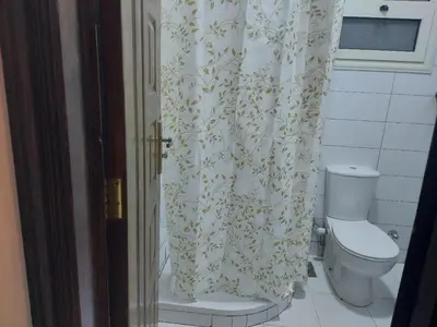a bathroom with a toilet and a shower curtain at one bed Apartment In Al Makramia in Hurghada