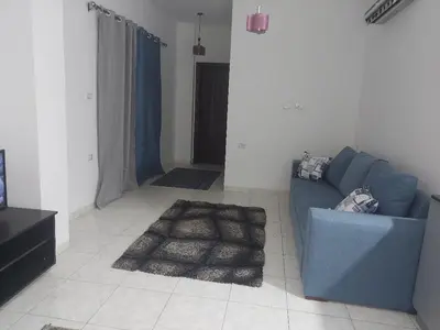 a living room with a blue couch and a rug at one bed Apartment In Al Makramia in Hurghada
