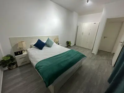 a bedroom with a large bed with a green blanket at Imperial Resort Apt Sleeps 3 - Pool Parking Wifi in Hurghada