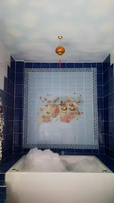 a bath tub in a bathroom with a blue tile wall at Pyramids Luxor Hotel & SPA in Luxor