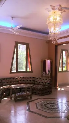 a living room with a couch and a chandelier at Pyramids Luxor Hotel & SPA in Luxor