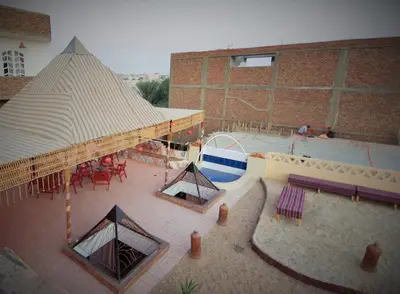 an overhead view of a swimming pool with a tent at Pyramids Luxor Hotel & SPA in Luxor